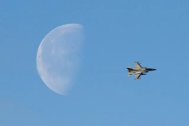 The moon is pictured as a Norwegian F-16 flys during a Joint demonstration of the NATO Trident Juncture 2018 exercise, in Byneset near Trondheim, Norway, October 30, 2018. Trident Juncture 2018, is a NATO-led military exercise held in Norway from 25 October to 7 November 2018. The exercise is the largest of its kind in Norway since the 1980s. Around 50,000 participants from NATO and partner countries, some 250 aircraft, 65 ships and up to 10,000 vehicles take part in the exercise. The main goal of Trident Juncture is allegedly to train the NATO Response Force and to test the alliance's defence capability. (Photo by Jonathan Nackstrand/AFP Photo)
