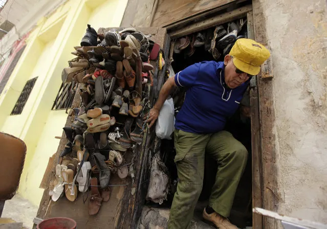 A man comes out of his shoe repair shop in Havana, Cuba, April 2010. (Photo by Desmond Boylan/Reuters)