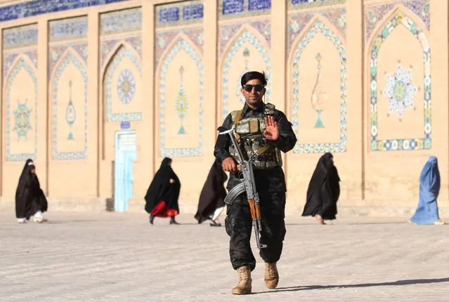 An Afghan security official stands guard as people arrive to offer Eid al-Adha prayers at a mosque in Herat, Afghanistan, 20 July 2021. The Afghan government and the Taliban have agreed to hold fresh discussions after peace talks in Doha ended over the weekend without an agreement over the situation in Afghanistan, which has witnessed unprecedented violence since the foreign troops began pulling out in May. Since May, the Taliban have captured more than 130 district centers across Afghanistan, especially in the northern parts of the country. (Photo by Jalil Rezayee/EPA/EFE)