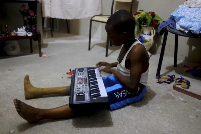 In this January 8, 2017 photo, Judeley Hans Debel, whose right leg is a prosthesis, plays an electric piano at his home in Petion-Ville, Haiti. Judeley was one of an estimated 4,000 to 6,000 people to undergo amputations after the powerful earthquake that devastated Haiti's capital seven years ago. (Photo by Dieu Nalio Chery/AP Photo)