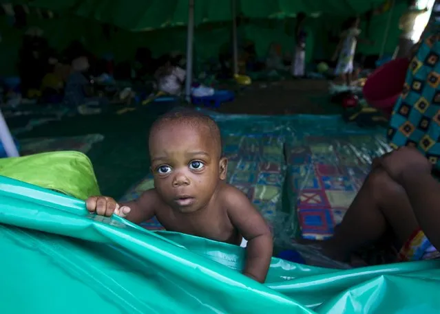 A foreign child plays in a tent on a sports field in Isipingo, south of Durban, April 9, 2015. Several hundred foreign nationals have sought refuge in the tents after xenophobia driven violence forced them to flee their homes. (Photo by Rogan Ward/Reuters)