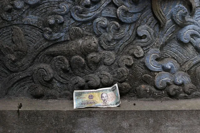 A bank note with portrait of Vietnamese late leader Ho Chi Minh is seen at the Quan Thanh Temple in Hanoi, Vietnam, Sunday, February 24, 2019. (Photo by Vincent Yu/AP Photo)
