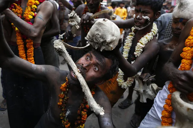 An Indian devotee holds a skull and a bone as he dances during a procession to mark Mahashivratri festival in Prayagraj, Uttar Pradesh state, India, Monday, March 4, 2019. “Shivaratri”, or the night of Shiva, is dedicated to the worship of Lord Shiva, the Hindu god of death and destruction. (Photo by Rajesh Kumar Singh/AP Photo)
