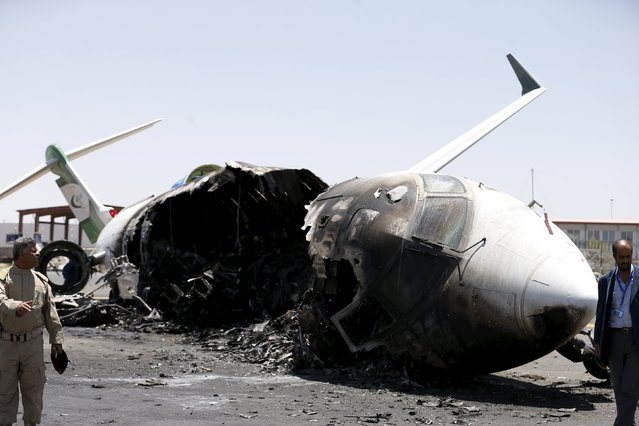 Airport officials stand by a Felix Airways plane, destroyed by an air strike at the international airport of Yemen's capital Sanaa, April 29, 2015. (Photo by Khaled Abdullah/Reuters)