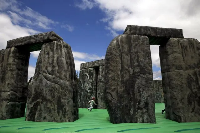 A girl plays on an inflatable replica of Stonehenge at a public park in Mostoles, Spain, April 27, 2015. The piece, entitled “Sacrilege”, is an interactive artwork by British artist Jeremy Deller, and it represents the megalithic monument of Stonehenge. (Photo by Susana Vera/Reuters)