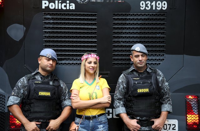 A demonstrator poses for picture with police officers during a protest against Brazil's President Dilma Rousseff, part of nationwide protests calling for her impeachment, in Sao Paulo, Brazil, March 13, 2016. (Photo by Nacho Doce/Reuters)