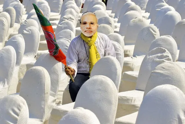 A volunteer of India's main opposition Bharatiya Janata Party (BJP), wearing a mask of Hindu nationalist Narendra Modi, prime ministerial candidate for BJP and Gujarat's chief minister, waits for the start of a rally where Modi will deliver an address, in Kolkata February 5, 2014. (Photo by Rupak De Chowdhuri/Reuters)