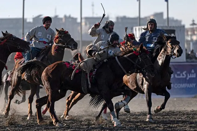 Afghan horsemen from Baghlan (in blue) and Sar-e Pol teams compete with each other during the fifth Buzkashi League in Kabul on December 28, 2023. (Photo by Wakil Kohsar/AFP Photo)