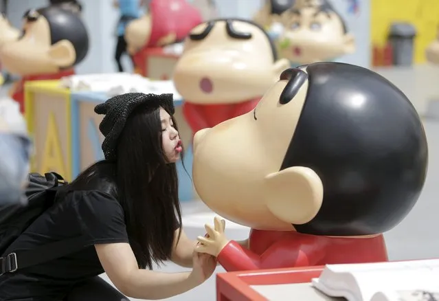 A visitor poses for a photo with a Crayon Shin-chan model during an exhibition at Joy City in Beijing May 5, 2015. (Photo by Jason Lee/Reuters)