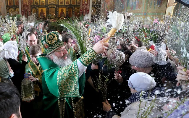 Metropolitan Kirill (C) of Yekaterinburg and Verkhoturye splashes holy water during a liturgy at the Cathedral of the Holy Trinity on Orthodox Palm Sunday in Yekaterinburg, Russia on April, 21, 2019. The Russian Orthodox Church celebrates feast days according to the Julian calendar. (Photo by Donat Sorokin/TASS)