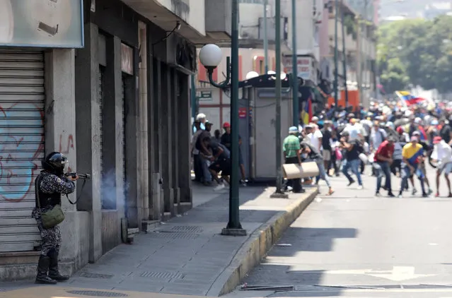 A government security forces member fires his weapon during clashes with protesters in Caracas, Venezuela April 30, 2019. (Photo by Manaure Quintero/Reuters)