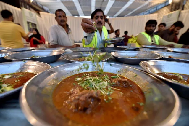 Meals are prepared for people to break their fast at an Iftar meal distributed by the student-led MESO Pakistan organization during the fasting month of Ramadan in Karachi, Pakistan, 22 March 2024. The Muslims' holy month of Ramadan is the ninth month in the Islamic calendar and it is believed that the revelation of the first verse in the Koran was during its last 10 nights. It is celebrated yearly by praying during the night time and abstaining from eating, drinking, and sexual acts during the period between sunrise and sunset. It is also a time for socializing, mainly in the evening after breaking the fast and a shift of all activities to late in the day in most countries. (Photo by Shahzaib Akber/EPA)