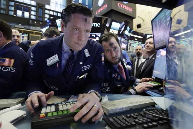 Specialists Gregg Maloney, left, and Michael Pistillo work at their post near the close of trading on the floor of the New York Stock Exchange, Wednesday, March 1, 2017. Banks and other financial companies led U.S. stocks sharply higher, pushing the Dow Jones industrial average to close above 21,000 points for the first time. (Photo by Richard Drew/AP Photo)