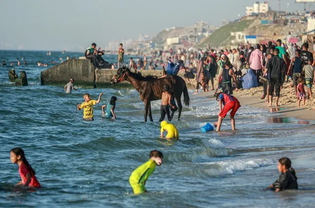 Palestinians enjoy the beach in Deir el-Balah in the central Gaza Strip on April 17, 2024, amid the ongoing conflict between Israel and the militant group Hamas. (Photo by AFP Photo)