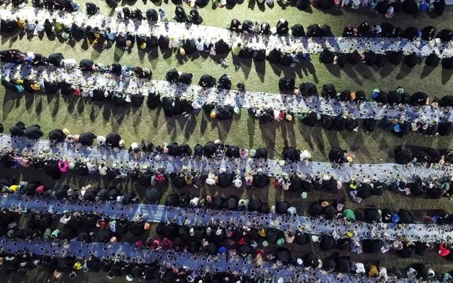 A drone view shows Muslims gathering for a free public Iftar meal organized by a charitable organization that cares for people in need during the holy fasting month of Ramadan, in Najaf, Iraq on March 22, 2024. (Photo by Alaa al-Marjani/Reuters)
