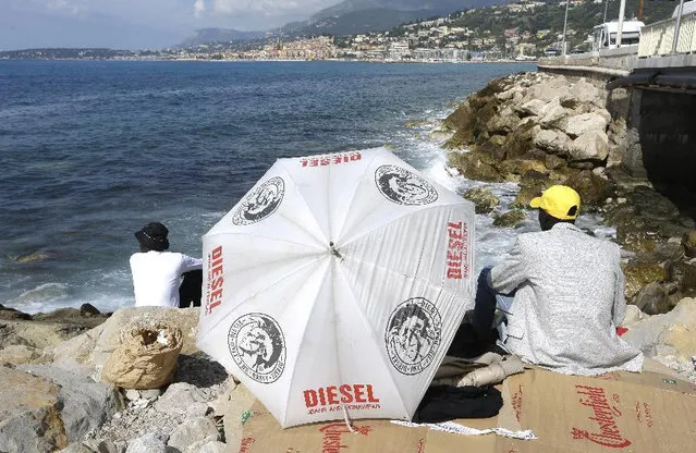 Migrants look at France side as they are blocked at the Franco-Italian border near Menton, southeastern France, Tuesday, June 16, 2015. Some 150 migrants, principally from Eritrea and Sudan, have been trying since last Friday to cross the border from Italy but have been blocked by French and Italian police. (AP Photo/Lionel Cironneau)