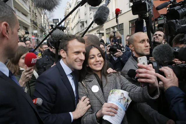 Independent centrist presidential candidate Emmanuel Macron poses for a selfie after a visit at a police station in the 20th district of Paris, Monday, March 13, 2017. The first French presidential ballot will take place on April 23 and the two top candidates go into a runoff on May 7. (Photo by Francois Mori/AP Photo)