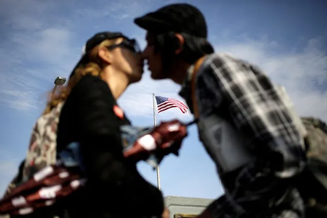 A flag of the U.S. flutters behind a Mexican couple kissing before crossing into El Paso, Texas, U.S. on the Paso del Norte international bridge, in this picture taken from Ciudad Juarez, Mexico on July 17, 2019. (Photo by Daniel Becerril/Reuters)