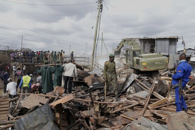 A bulldozer demolishes houses during a government ordered demolition of illegally constructed structures on riparian land in the Mukuru area of Nairobi, Kenya, Tuesday, May 7, 2024. (Photo by Brian Inganga/AP Photo)