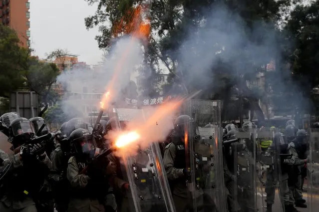 Police officers fire tear gas at demonstrators during a protest against the Yuen Long attacks in Yuen Long, New Territories, Hong Kong, China July 27, 2019. Activists held the march in Yuen Long, scene of the attack by club-wielding men, despite a police ban on safety grounds. (Photo by Tyrone Siu/Reuters)