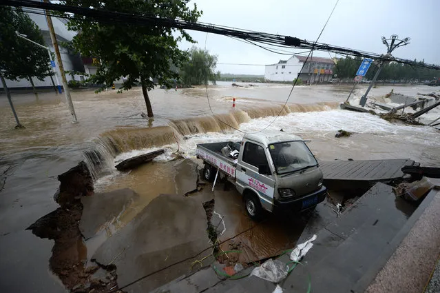 A car is devastated by the floodwater due to rainstorms caused by Typhoon Lekima, the 9th typhoon of the year, in Ji'nan city, east China's Shandong province on August 13, 2019. Some 12.88 million people in nine provincial-level regions of China had been affected by Typhoon Lekima as of 4 p.m. Tuesday (12 August 2019), the Ministry of Emergency Management said. About 2 million people in the provinces of Zhejiang, Jiangsu, Shandong, Anhui, Fujian, Hebei, Liaoning and Jilin as well as the city of Shanghai had been relocated, the ministry said. Nearly 13,000 houses collapsed and some 119,000 were damaged, while 996,000 hectares of crops were affected by the typhoon. (Photo by Imaginechina/Shutterstock)