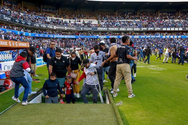 Fans of Queretaro and Atlas clash during a Mexican soccer league match at the Corregidora stadium, in Queretaro, Mexico, Saturday, March 5, 2022. The match was suspended after fans invaded the field. (Photo by Eduardo Gomez Reyna/AP Photo)