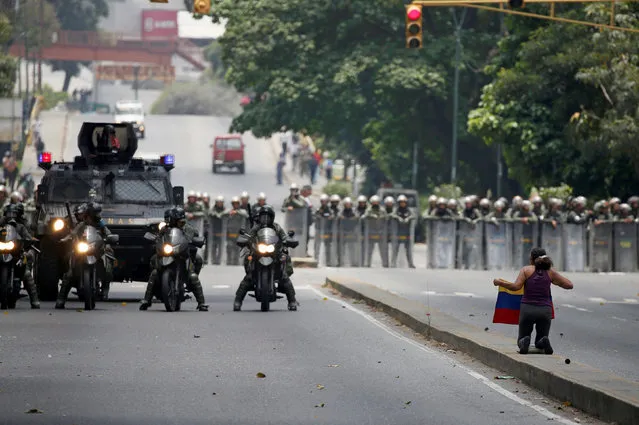 A demonstrator knees in front of riot police during a rally against Venezuela's President Nicolas Maduro in Caracas, Venezuela April 20, 2017. (Photo by Carlos Eduardo Ramirez/Reuters)