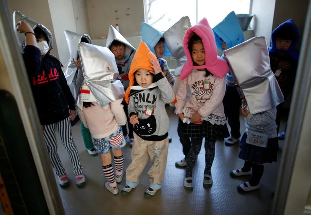 School children wearing padded hoods to protect themselves from falling debris take part in an earthquake simulation exercise in an annual evacuation drill at an elementary school in Tokyo, Japan March 10, 2017, a day before the six-year anniversary of the March 11, 2011 earthquake and tsunami disaster that killed thousands and set off a nuclear crisis. (Photo by Issei Kato/Reuters)