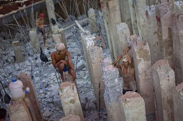 Myanmar construction workers partially demolish a foundation of a building under construction in Yangon, Myanmar, Tuesday, May 17, 2016. According to the Asian Development Bank's latest outlook report Myanmar's economy is expected to grow at a rapid 8.4 percent in 2016, the highest in Asia. (Photo by Gemunu Amarasinghe/AP Photo)
