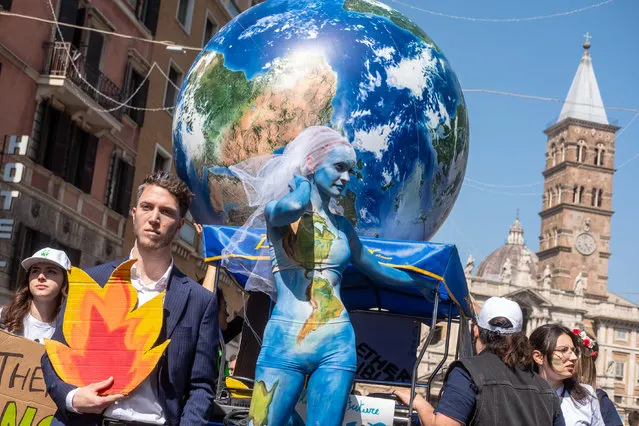 Demonstrators of the Fridays for Future movement march in downtown Rome, Friday, March 25, 2022. Climate activists staged a tenth series of worldwide protests Friday to demand leaders take stronger action against global warming, with some linking their environmental message to calls for an end to the war in Ukraine. (Photo by Mauro Scrobogna/LaPresse via AP Photo)