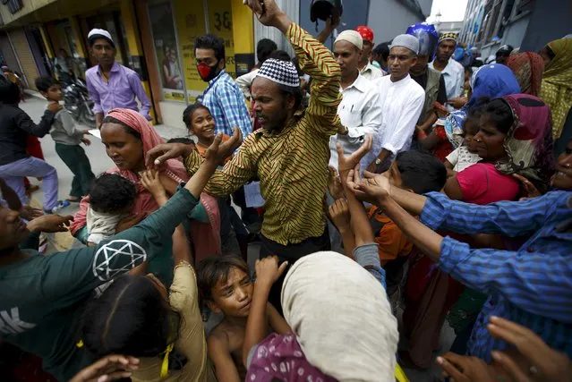 People begging for alms gather around a Muslim man as he walks out from the mosque after attending Friday prayers during the Muslim holy month of Ramadan in Kathmandu, July 17, 2015. (Photo by Navesh Chitrakar/Reuters)