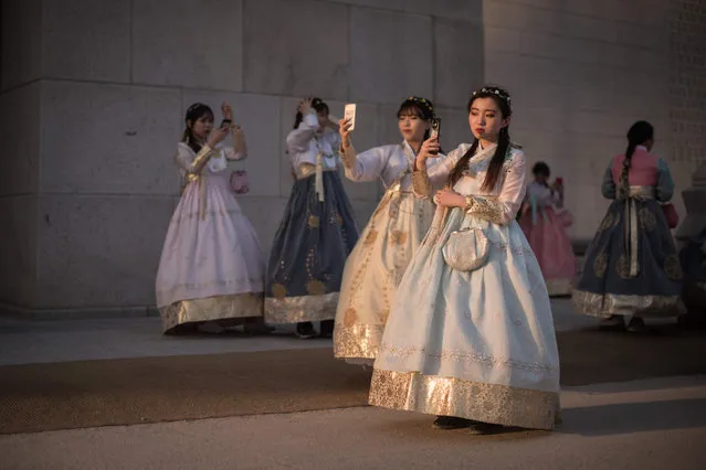 In this picture taken on May 3, 2017, a group of women wearing traditional hanbok dress take selfies outside Gyeongbokgung palace in Seoul South Koreans will vote for their next president on May 9. (Photo by Ed Jones/AFP Photo)