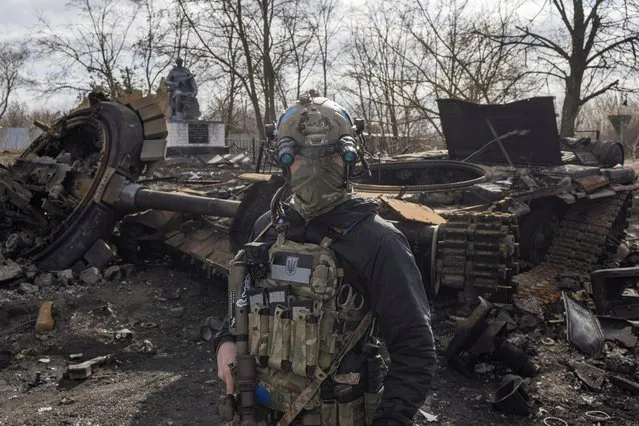 A Ukranian serviceman walks past the wreck of a Russian tank in the village of Lukyanivka outside Kyiv, as Russia's invasion of Ukraine continues, Ukraine, March 27, 2022. (Photo by Marko Djurica/Reuters)