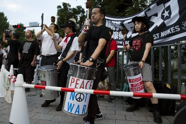 Protesters beat drums as they sit at the fringes of a demonstration against Japan's Prime Minister Shinzo Abe's security-related legislation outside the parliament building in Tokyo, July 17, 2015. (Photo by Thomas Peter/Reuters)