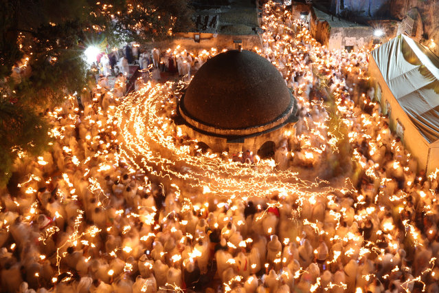 Ethiopian Orthodox Christian pilgrims hold candles during a ceremony of the “Holy Fire” at the Deir Al-Sultan Monastery on the roof of the Holy Sepulchre Church in Jerusalem's Old City on April 15, 2023, on the eve of Orthodox Easter. (Photo by Ahmad Gharabli/AFP Photo)