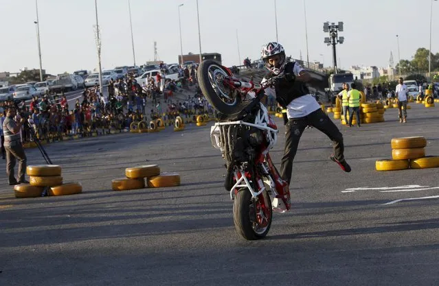 A youth riding a motorcycle performs a wheelie during the “Peace and Security” event in Tripoli, Libya July 23, 2015. (Photo by Ismail Zitouny/Reuters)