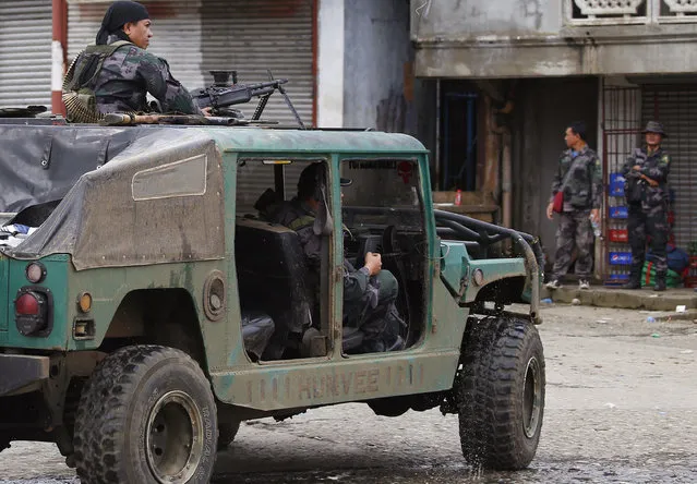 Police patrol the streets of Marawi city as government troops battle with Muslim militants who continue to hold their ground in some areas of the city for almost a week Monday, May 29, 2017 in southern Philippines. Philippine forces control most of the southern city where militants linked to the Islamic State group launched a bloody siege nearly a week ago, authorities said Monday, as the army launched airstrikes and went house-to-house to crush areas of resistance. (Photo by Bullit Marquez/AP Photo)