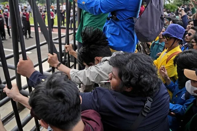 Students rock the gate of the parliament building during a rally in Jakarta, Indonesia, Monday, April 11, 2022. (Photo by Dita Alangkara/AP Photo)