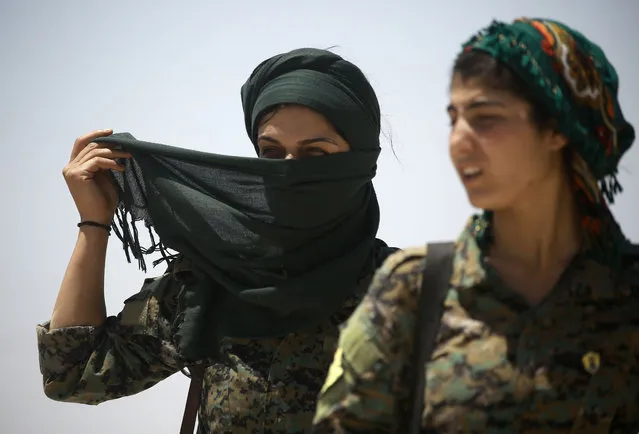 Members of the Syrian Democratic Forces (SDF), made up of an alliance of Kurdish and Arab fighters, stand some two kilometres from the Al- Meshleb neighbourhood of Raqa as they try to advance further into the Islamic State (IS) group' s Syrian bastion, on June 7, 2017 two days after finally entering the northern city. The SDF alliance began the battle for the city earlier this week after seven months of fighting to surround the key jihadist stronghold. (Photo by Delil Souleiman/AFP Photo)