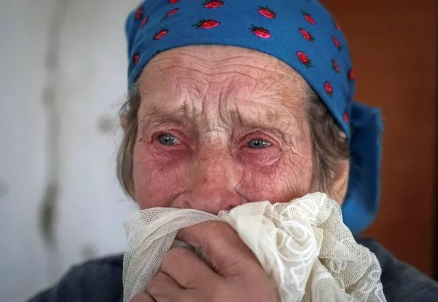 Local resident Katerina Bondarevich, 83, reacts inside her house after it was damaged by yesterday's shelling, amid Russia's invasion, in the village of Komyshuvakha, Ukraine on May 12, 2022. (Photo by Gleb Garanich/Reuters)