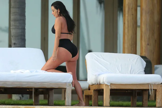 Kim Kardashian relaxing by the pool while enjoying a second honeymoon in Mexico with Kanye West. Kim showed off her fabulous figure in black, high waisted, retro bikini-bottoms and matching top. The newly-weds stayed at the exclusive home of Girls Gone Wild founder Joe Francis, after jetting in to Punta Mita, to catch some pool side relaxation – and celebrate Kanye's 37th birthday. The Wests honeymooned in Ireland and Prague after their May 24 wedding in Italy. (Photo by Brian Prahl/Splash News)