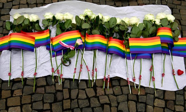 White roses and rainbow flags are displayed in front of the US Embassy in Berlin on June 13, 2016 as people pay tribute to the victims of the Orlando killing. Fifty people died when a gunman allegedly inspired by the Islamic State group opened fire inside a gay nightclub in Florida, in the worst terror attack on US soil since September 11, 2001. (Photo by John MacDougall/AFP Photo)