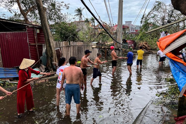 People remove fallen trees following the impact of Typhoon Yagi, in Hai Phong, Vietnam, on September 8, 2024. (Photo by Minh Nguyen/Reuters)