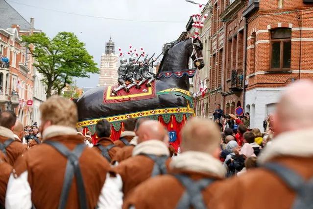 People attend the “Ros Beiaardommegang” procession featuring the heroic horse, Ros Beiaard, in Dendermonde, Belgium on May 29, 2022. The parade should have taken place in 2020, but was postponed twice due to the Covid-19 pandemic. (Photo by Nicolas Maeterlinck/BELGA via AFP Photo)