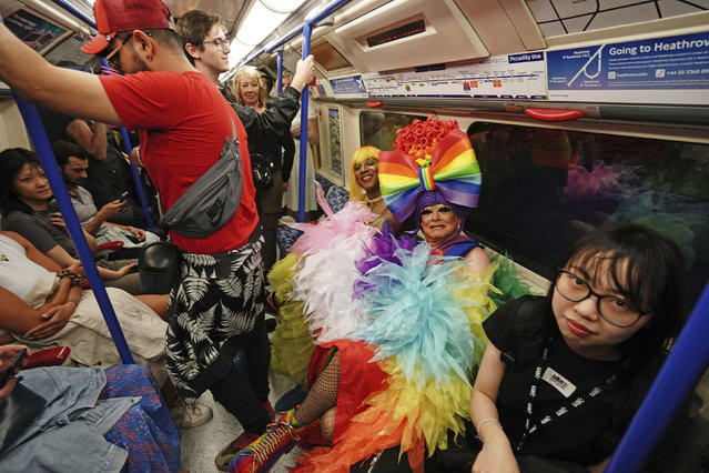 People travel by tube on the London Underground to take part in the Pride in London parade, London, Saturday, July 1, 2023. (Photo by Jordan Pettitt/PA Wire via AP Photo)