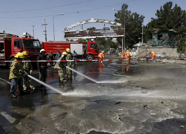 Afghan workers clear debris from the site of a car bomb blast at the entrance gate to the Kabul airport, Afghanistan August 10, 2015. (Photo by Mohammad Ismail/Reuters)
