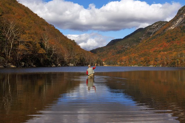 A man fly fishes in Profile Lake while surrounded by the fall foliage colors in Franconia Notch State Park in Franconia, New Hampshire, USA, 03 October 2024. The peak foliage season is beginning in New England. (Photo by Cj Gunther/EPA/EFE)