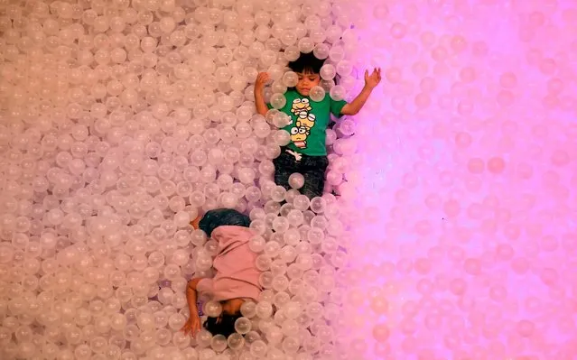 Children play in a ball pit at a shopping mall in Bangkok on December 29, 2019. (Photo by Lillian Suwanrumpha/AFP Photo)
