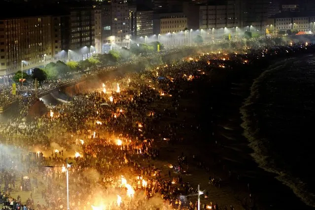 People celebrate St. John's night (San Juan) around bonfires on Orzan beach, in A Coruna, Spain on June 24, 2022. (Photo by Nacho Doce/Reuters)