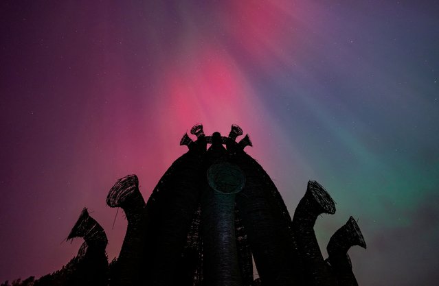 The Northern Lights, also known as aurora borealis, caused by a strong solar storm, light the sky near the Bobur art installation at the art park in the village of Nikola Lenivets, Kaluga region, Russia, on October 11, 2024. (Photo by Maxim Shemetov/Reuters)